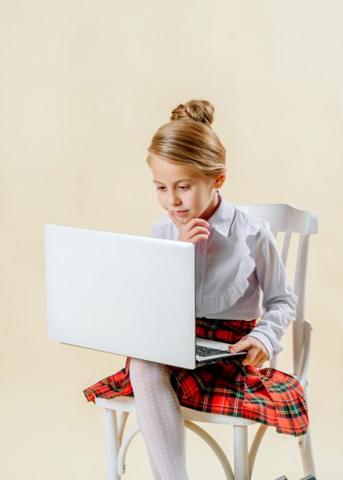 little-girl-school-age-looks-laptop-light-background-internet-addiction_119439-339